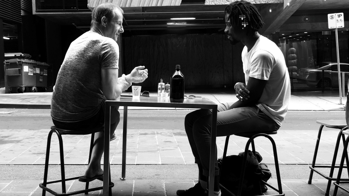 exemplo de fluência com dois homens conversando num local público