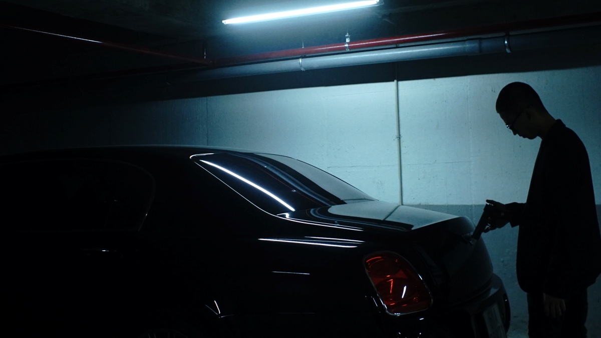 culture of guns man holding handgun standing at the back of a car